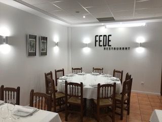 Comedor con mesa redonda y sillas, apliques de pared y letrero de 