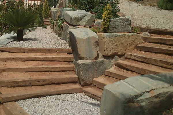 Un conjunto de escaleras hechas de madera y rocas en un jardín.