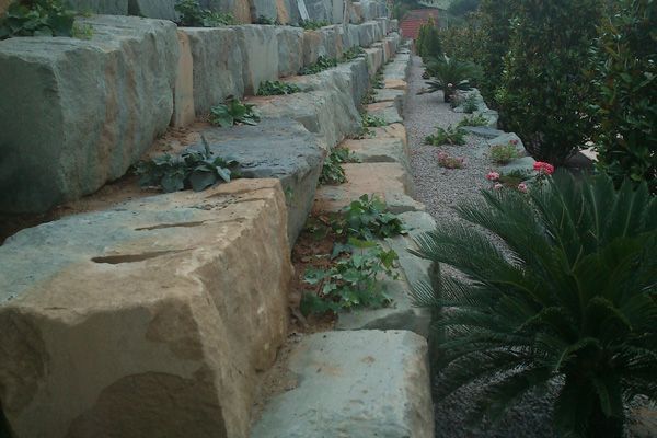 Una hilera de rocas grandes colocadas una al lado de la otra en un jardín.