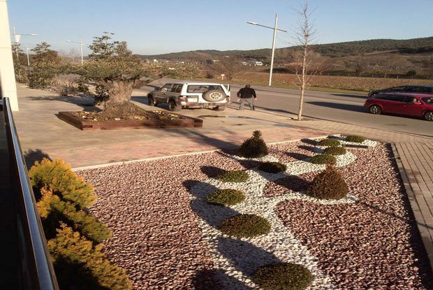 Un coche está aparcado al costado de la carretera al lado de una zona de grava.
