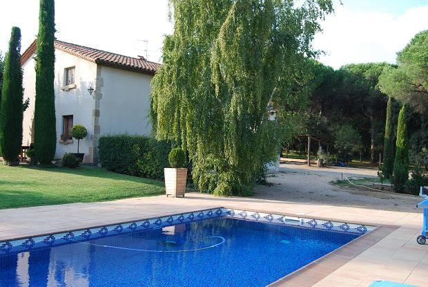 Una gran piscina con una casa al fondo.