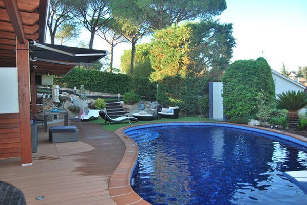 Una gran piscina rodeada de sillas y árboles.