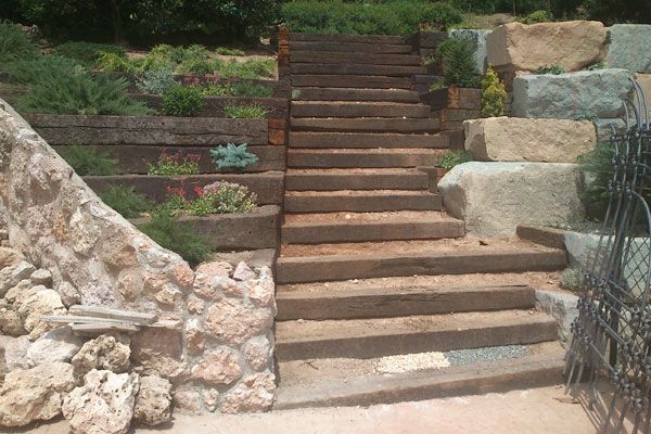 Un conjunto de escaleras de madera que conducen a un muro de piedra.