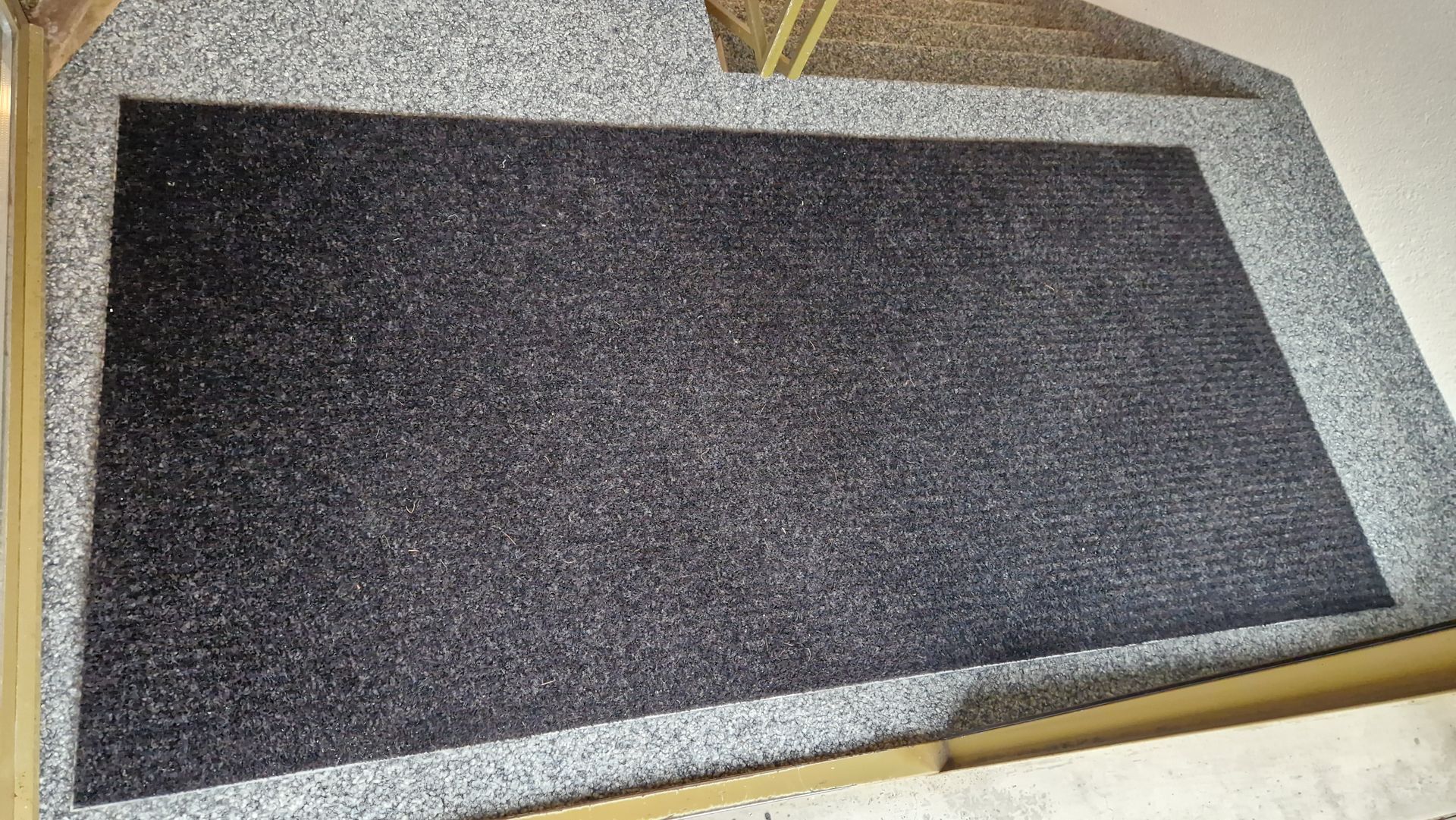 Auf einer Treppe liegt eine schwarze Matte.