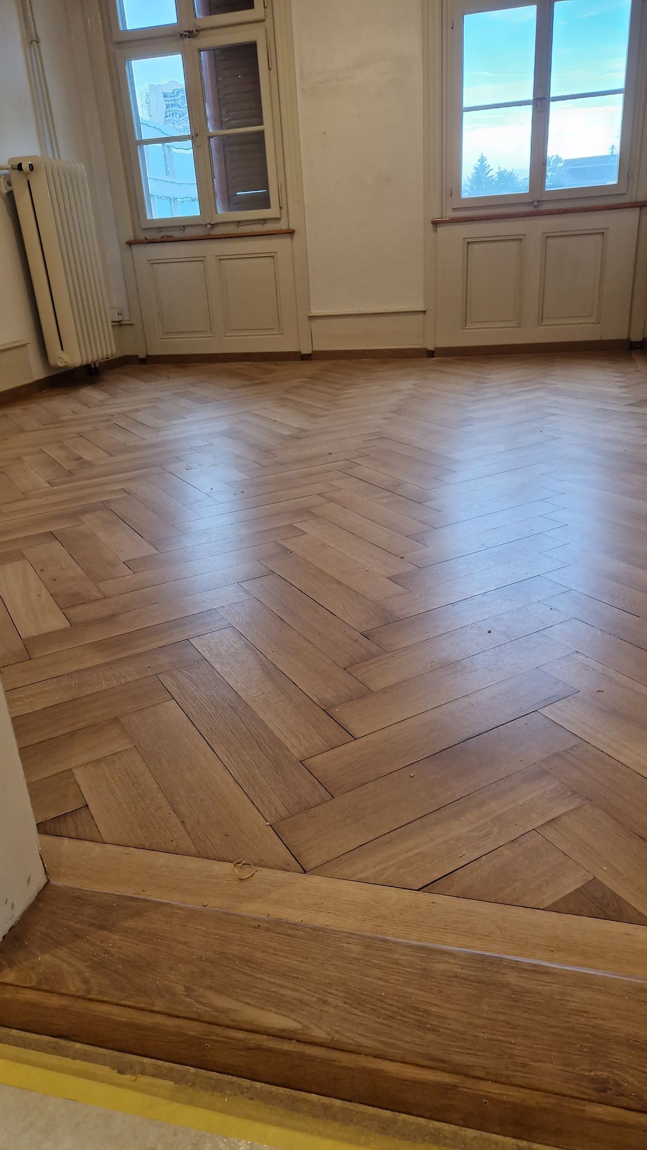 Ein Raum mit Holzboden und Fenster.