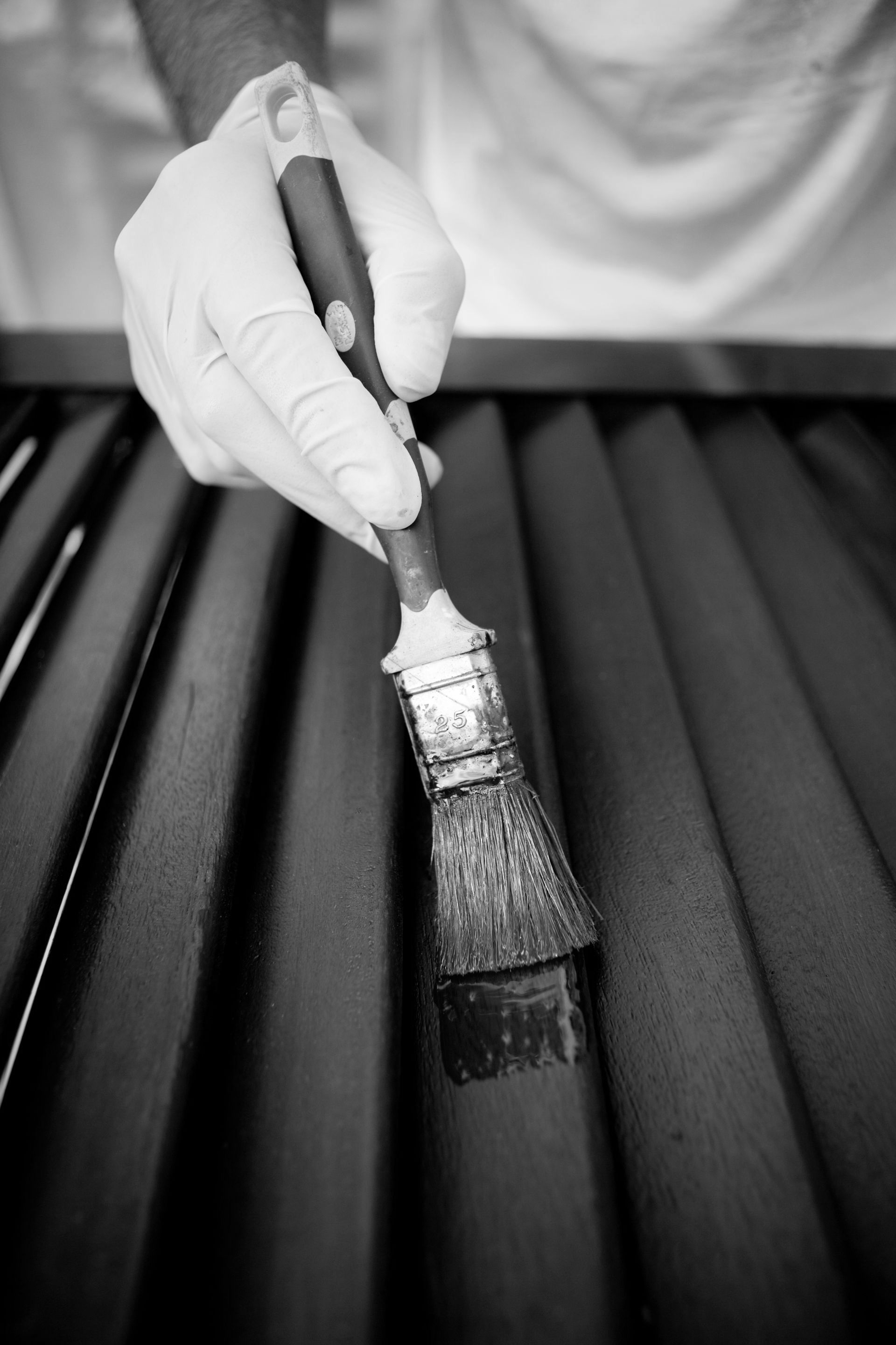 Homme peignant une persienne