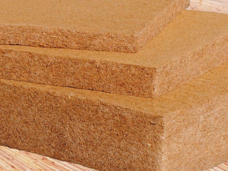 Pile de panneaux isolants rectangulaires en fibre de coco marron.
