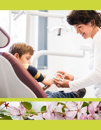 Ein Zahnarzt demonstriert einem Patienten auf einem Behandlungsstuhl anhand eines Modells die richtige Mundpflege;