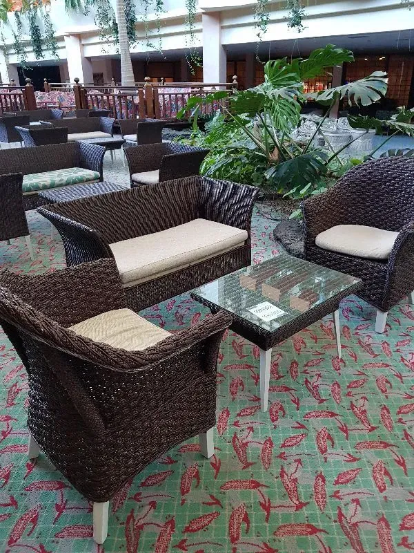 Una sala de estar con muebles de mimbre y una mesa.