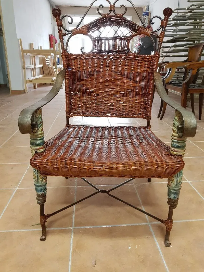 Una silla de mimbre está colocada sobre un suelo de baldosas en una habitación.