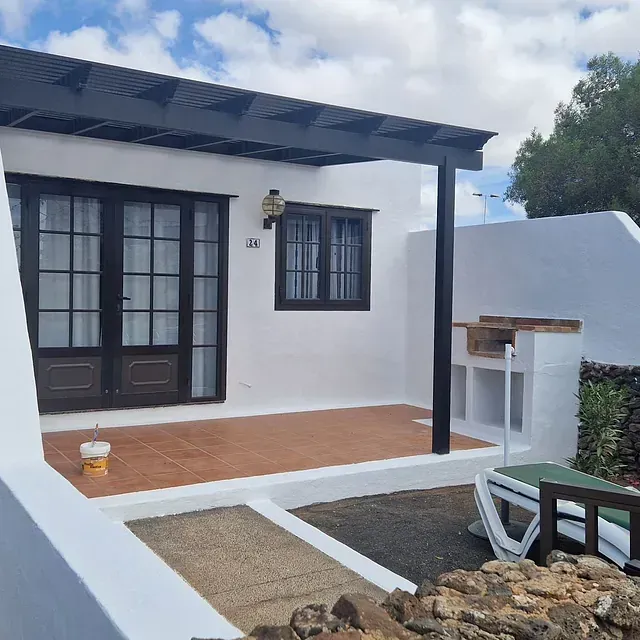 Una casa blanca con techo negro tiene el número 13.