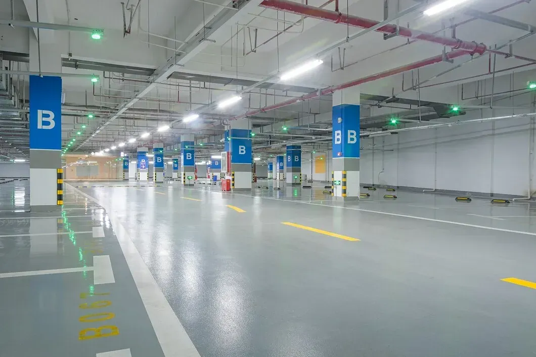 Un estacionamiento subterráneo vacío con muchas luces encendidas.