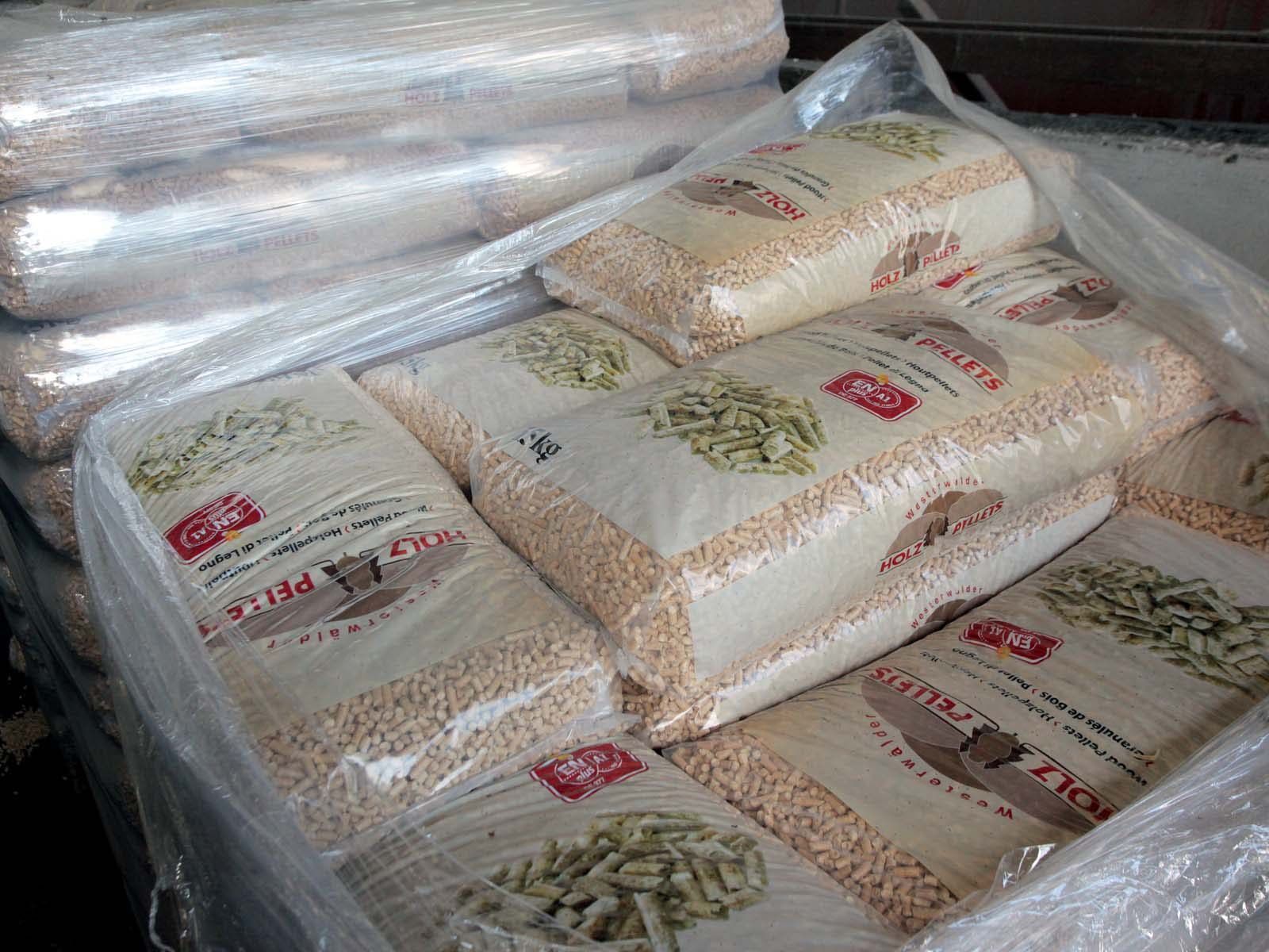 Un important stock de sacs en plastique transparents et scellés contenant des granules, dans un entrepôt.