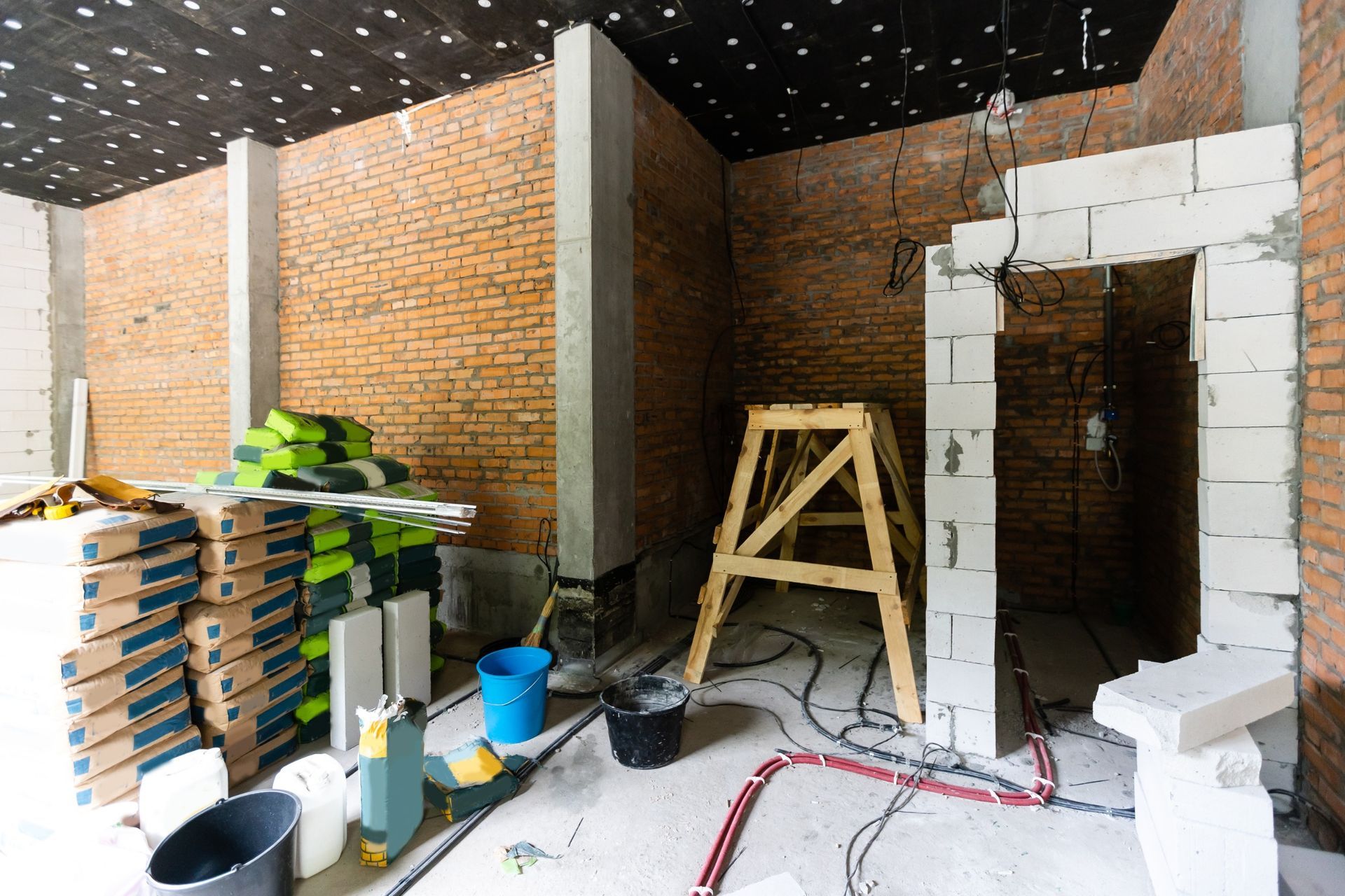Una habitación en construcción con paredes de ladrillo y bloques blancos.