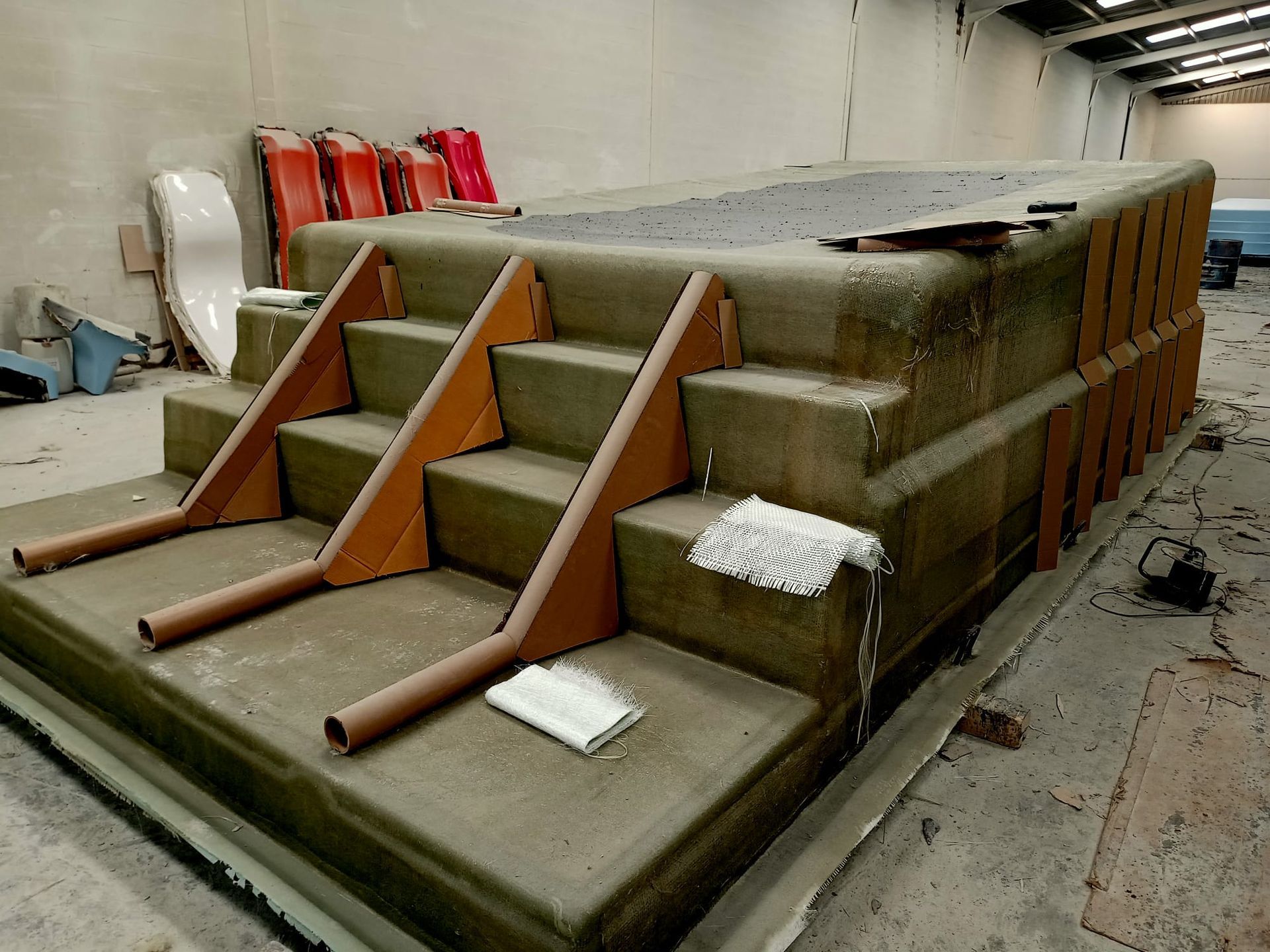 Una gran estructura de hormigón con escaleras de madera en un almacén.