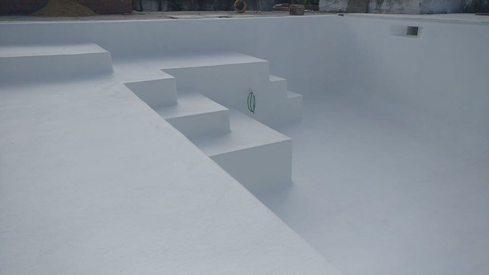 Piscina blanca, vacía y con escalones.