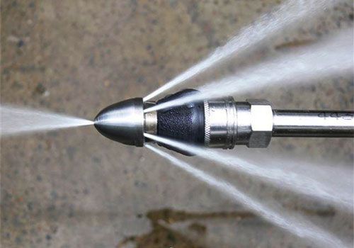 Buse d'arrosage projetant plusieurs jets d'eau sur le trottoir