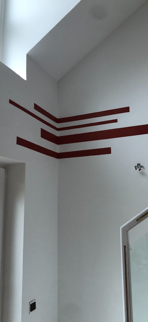 Abstraktes Design mit horizontalen roten Linien auf einer weißen Wand