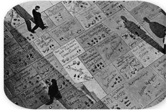 Una fotografía en blanco y negro de personas caminando por una acera.