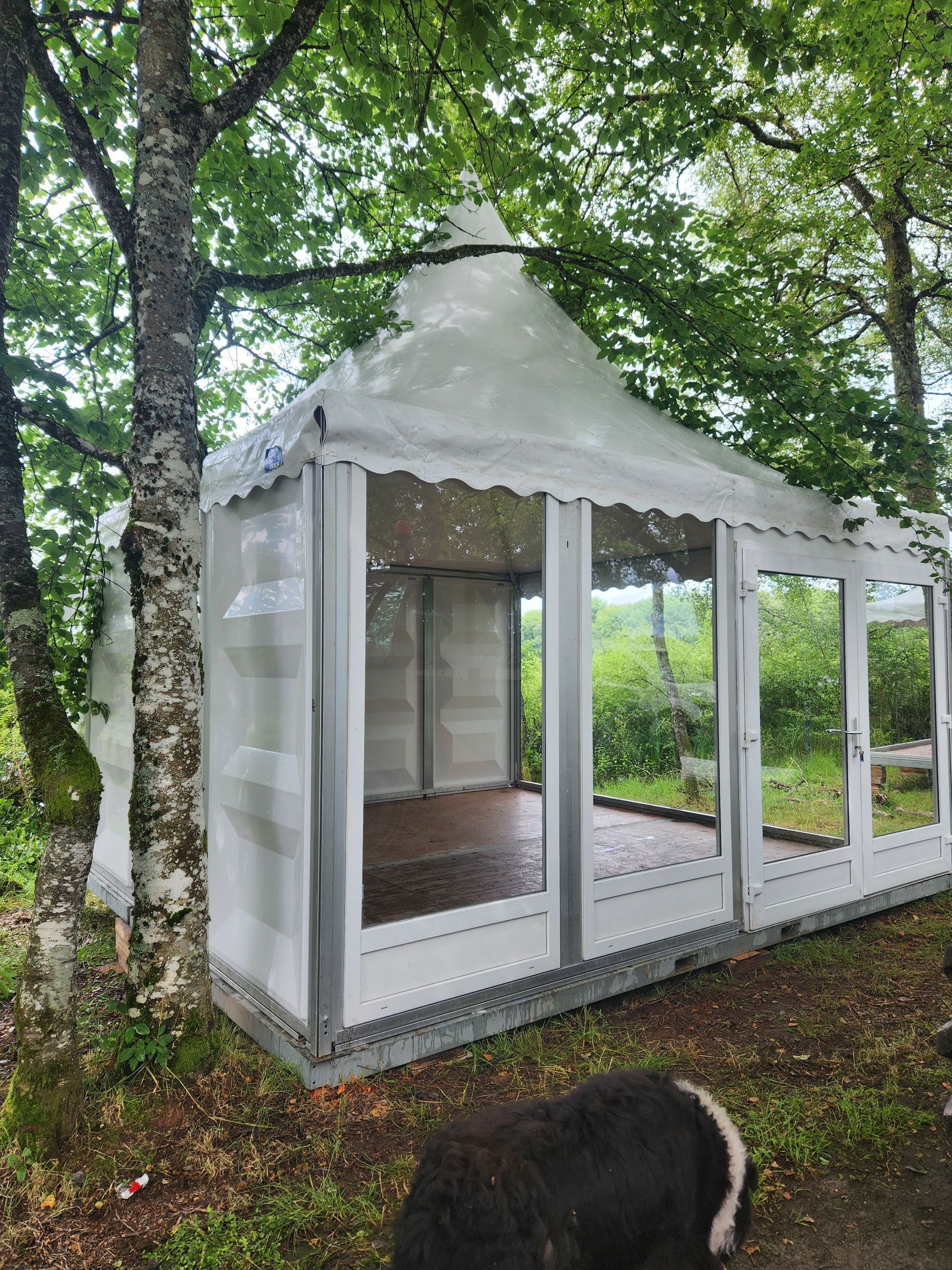 Tente blanche à côté d'une vielle maison