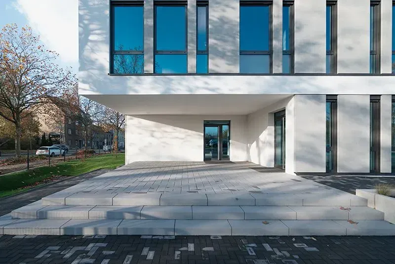 Ein großes weißes Gebäude mit vielen Fenstern und Treppen, die nach oben führen. Foto von der Metallbau Schilloh GmbH