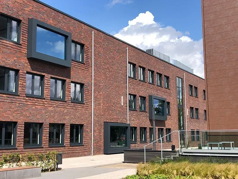 Ein großes Backsteingebäude mit vielen Fenstern. Foto von der Metallbau Schilloh GmbH