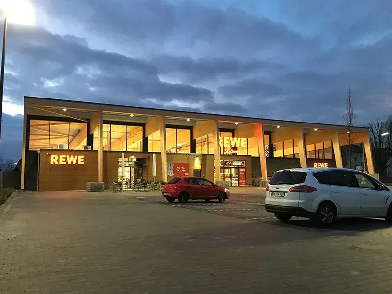 Vor einem Rewe-Laden parken zwei Autos. Foto von der Metallbau Schilloh GmbH