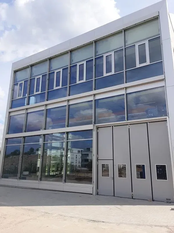 Ein großes Gebäude mit vielen Fenstern und Türen. Foto von der Metallbau Schilloh GmbH