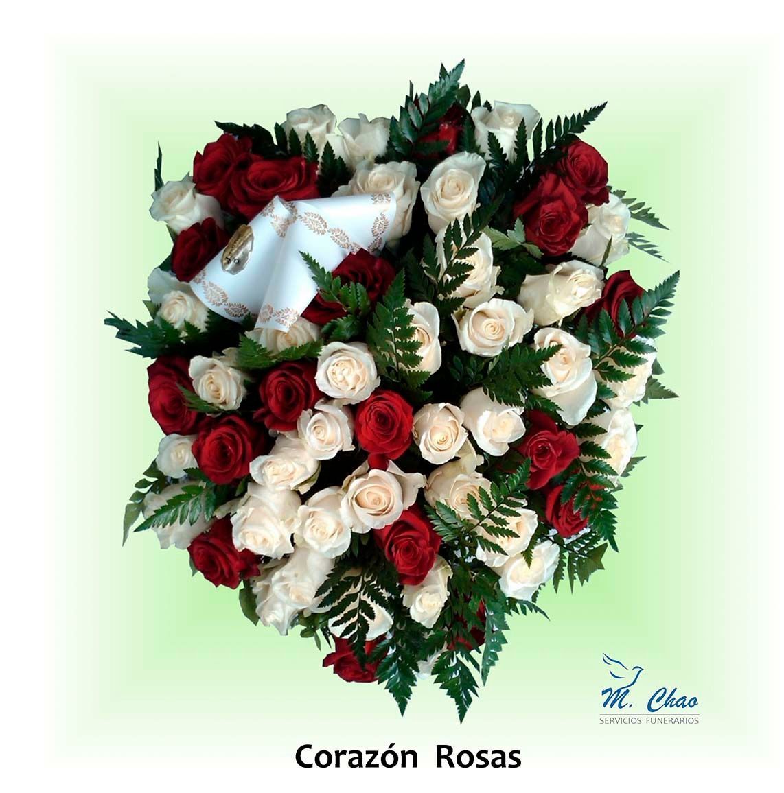 Un arreglo en forma de corazón de rosas rojas y blancas.