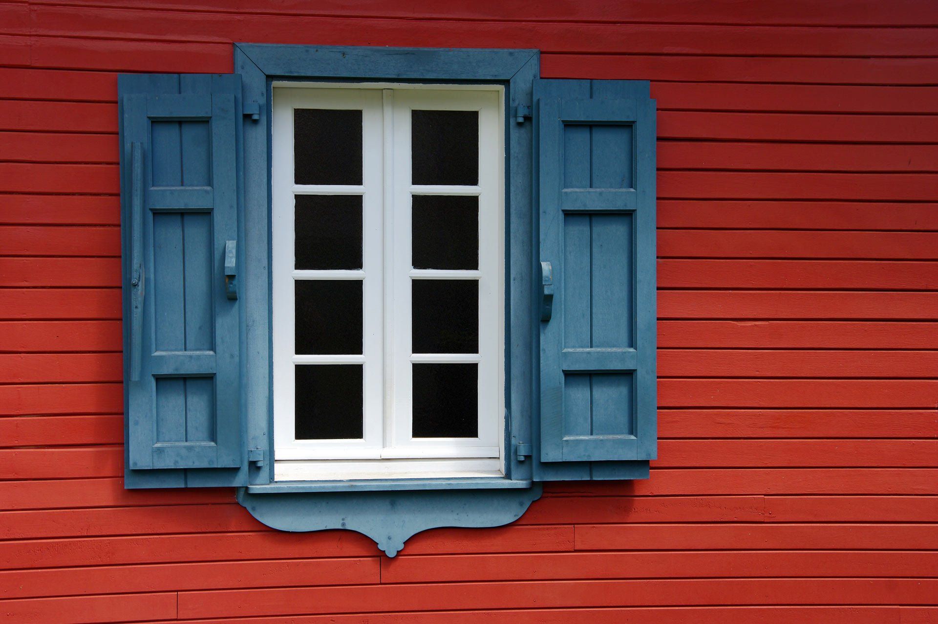 Maison en bois peinte en rouge et bleu
