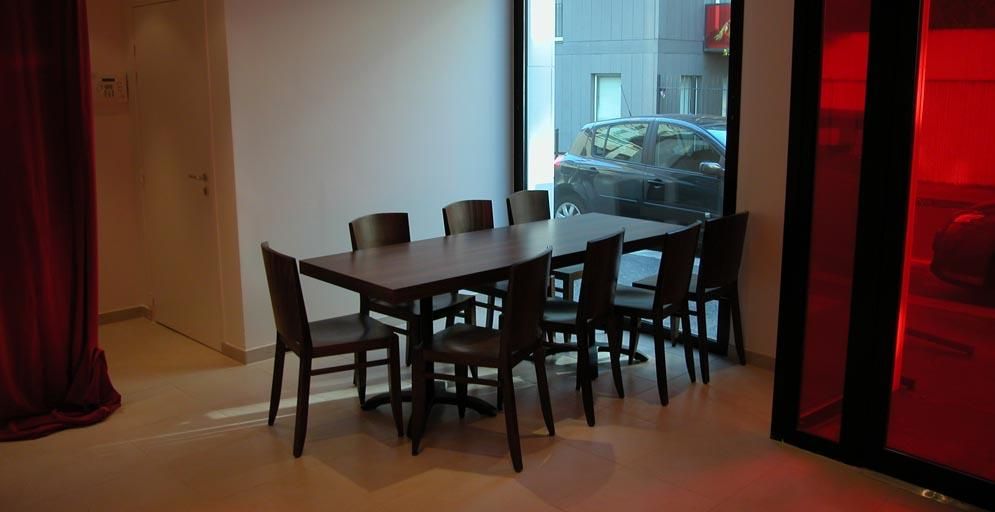 Table marron sombre devant une fenêtre