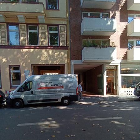 Ein Lieferwagen, der vor einem Gebäude mit der Aufschrift „Duck Hansen“ geparkt ist