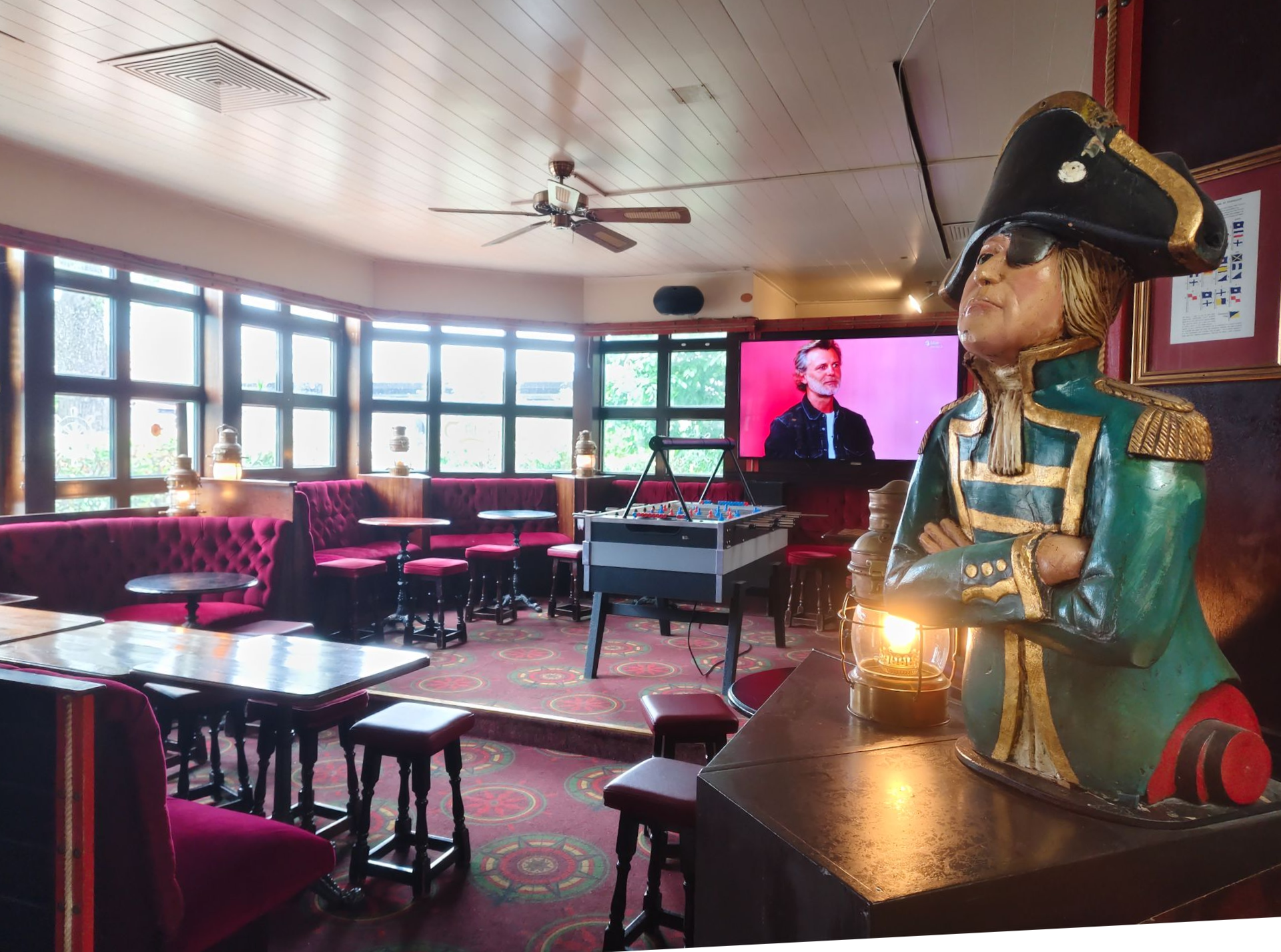 Bartheke mit Bierhähnen, Flaschen, Gläsern und einem kleinen Schild in einem schwach beleuchteten Pub