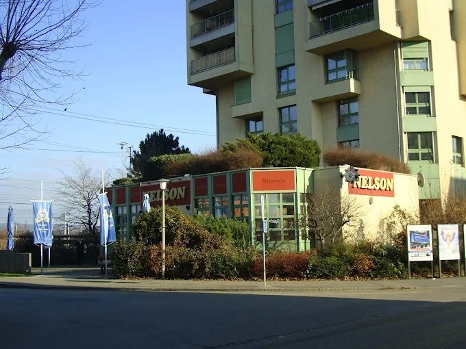 Strassenansicht eines Gebäudes mit Schaufensterläden und roten Schildern neben einer Strasse