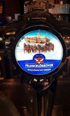 Hinterleuchteter Feldschlösschen-Bierhahn mit Winterszene und schneebedecktem Schloss-Etikett