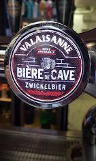 Rundes Brauereischild mit der Aufschrift „La Maison de la Bière de Cave Zwickelbier“ in Weiss auf schwarzem Hintergrund