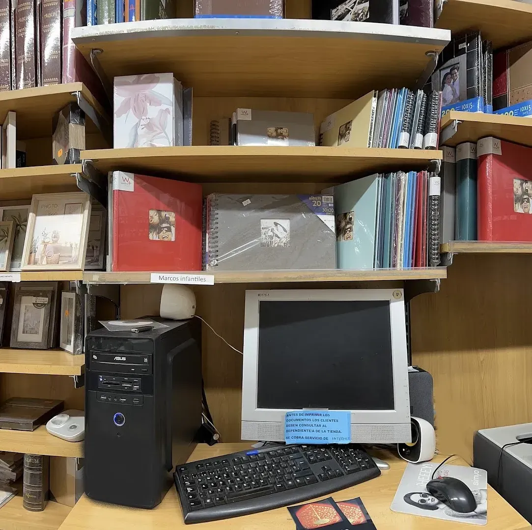 Una computadora está sobre un escritorio en una biblioteca.