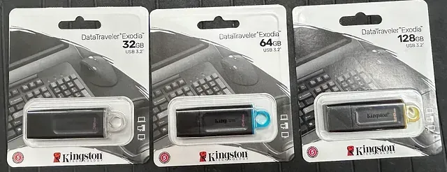 Hay tres unidades flash Kingston una al lado de la otra sobre una mesa.