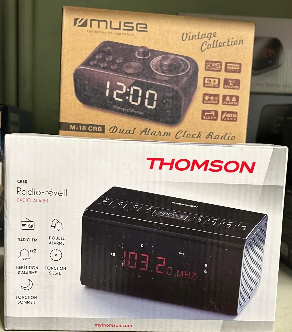 Un radio reloj despertador doble Thomson se encuentra junto a un radio reloj de la colección vintage Muse.