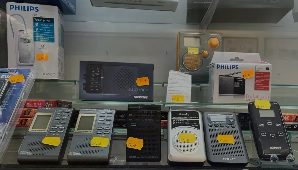 Una exhibición de varias radios Philips en un estante de vidrio.