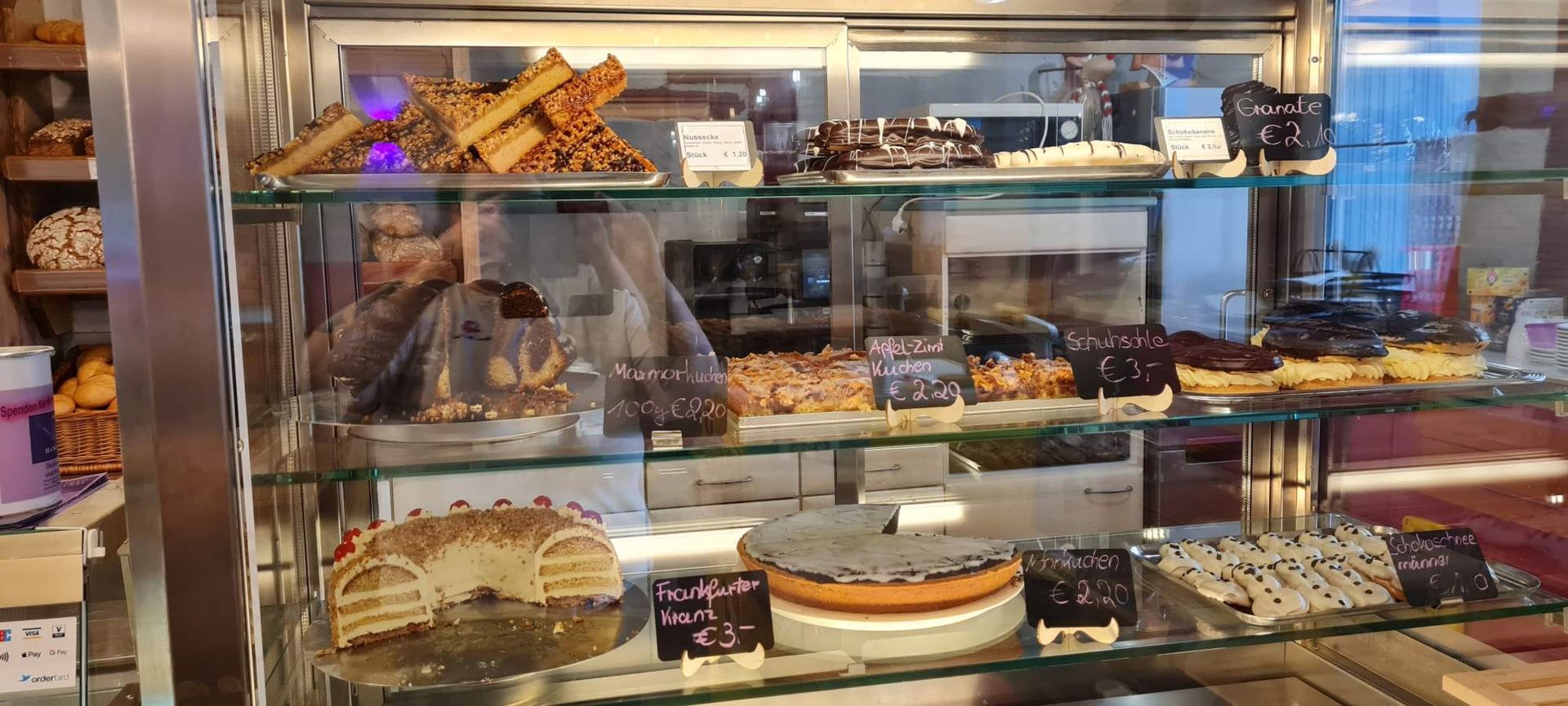 Die Auslage der Bäckerei ist gefüllt mit verschiedenen Kuchen und Gebäcksorten.