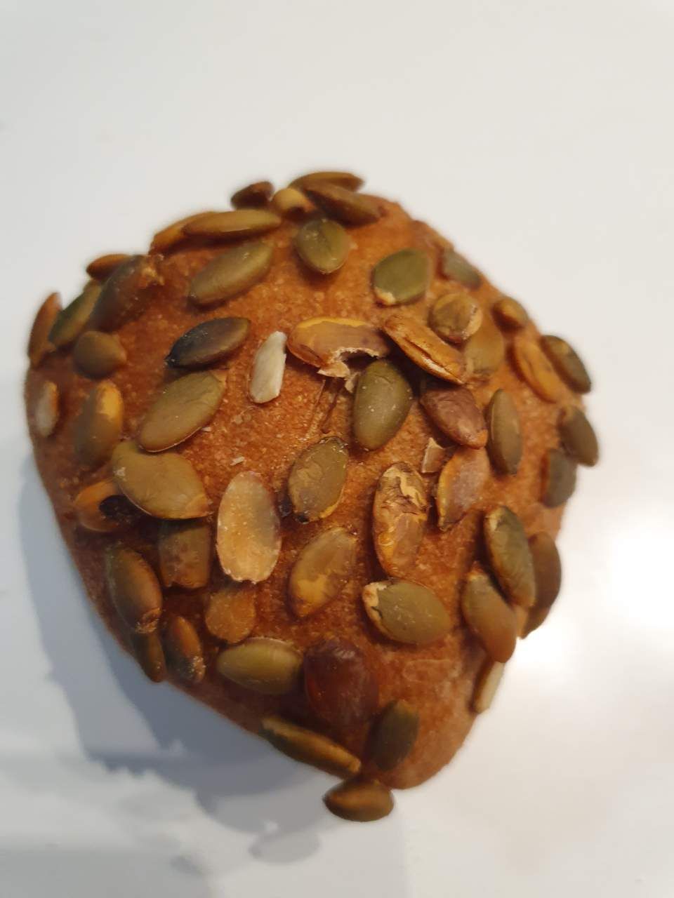 Mit Kürbiskernen auf einer weißen Oberfläche rollen.