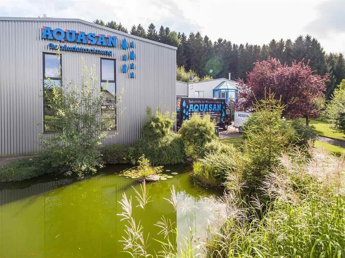 Ein großes Gebäude mit einem Teich davor.