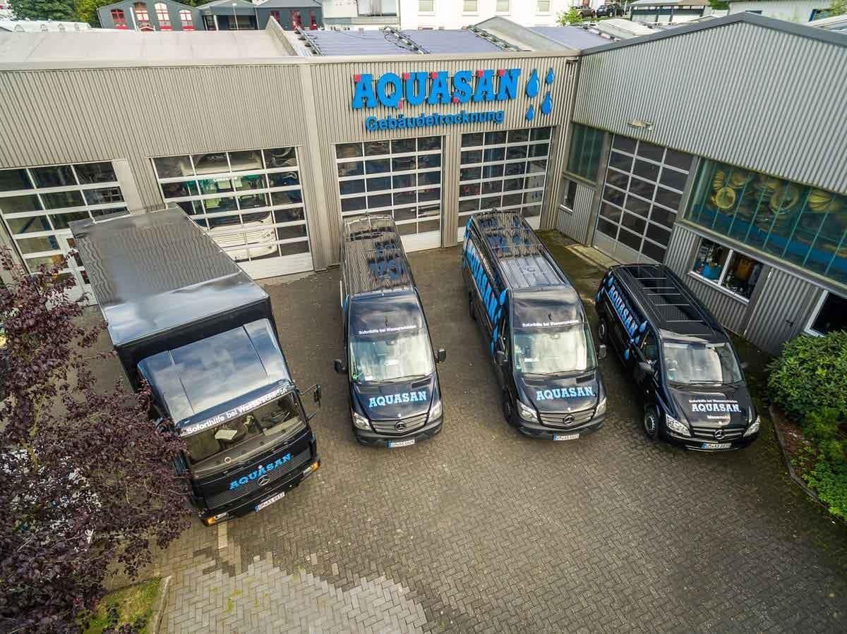 Eine Gruppe Lieferwagen parkt vor einem Gebäude.