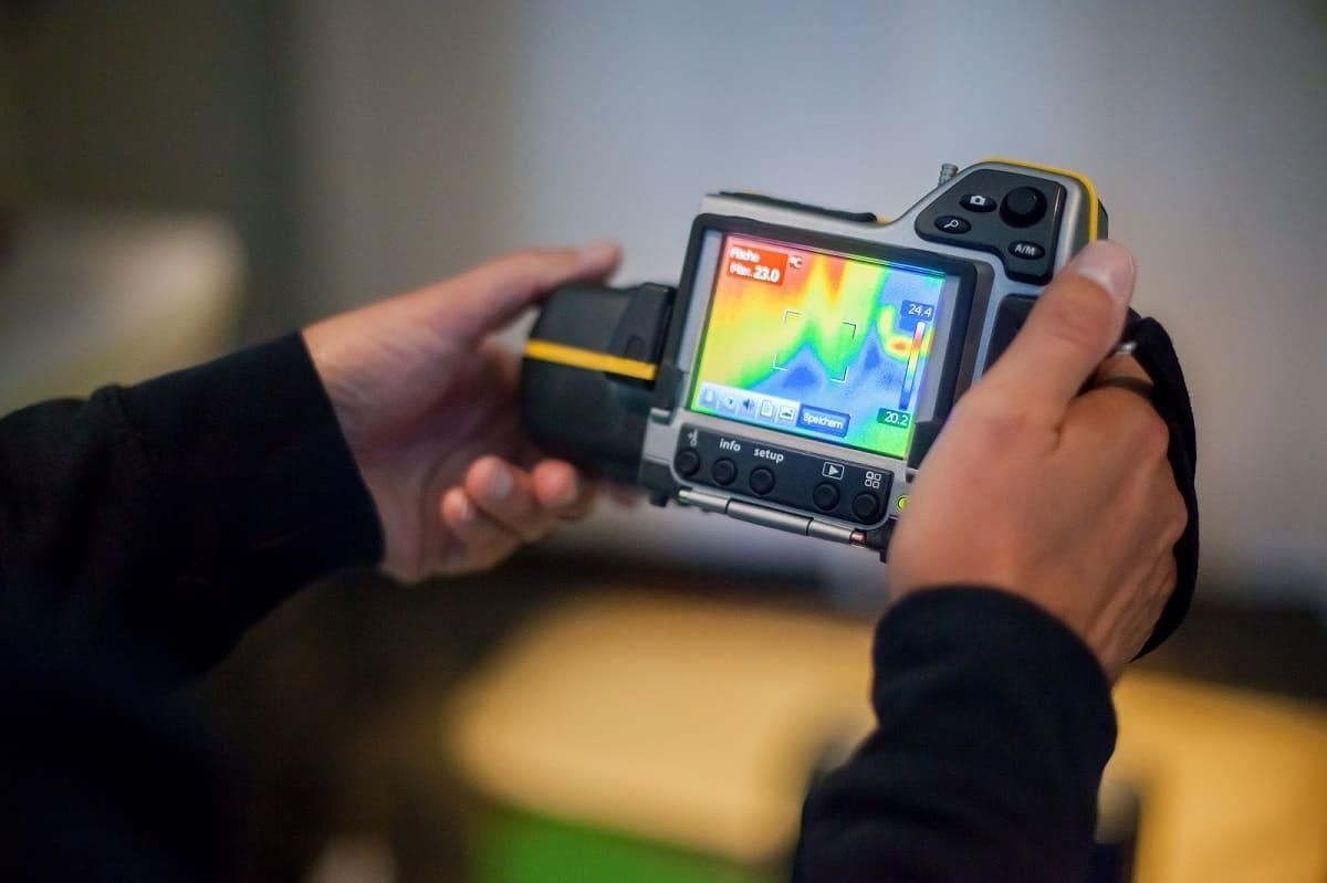 Eine Person hält eine Wärmebildkamera in den Händen.