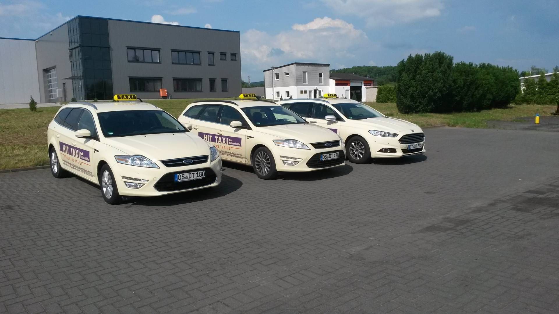 drei weiße und lila Taxen stehen nebeneinander