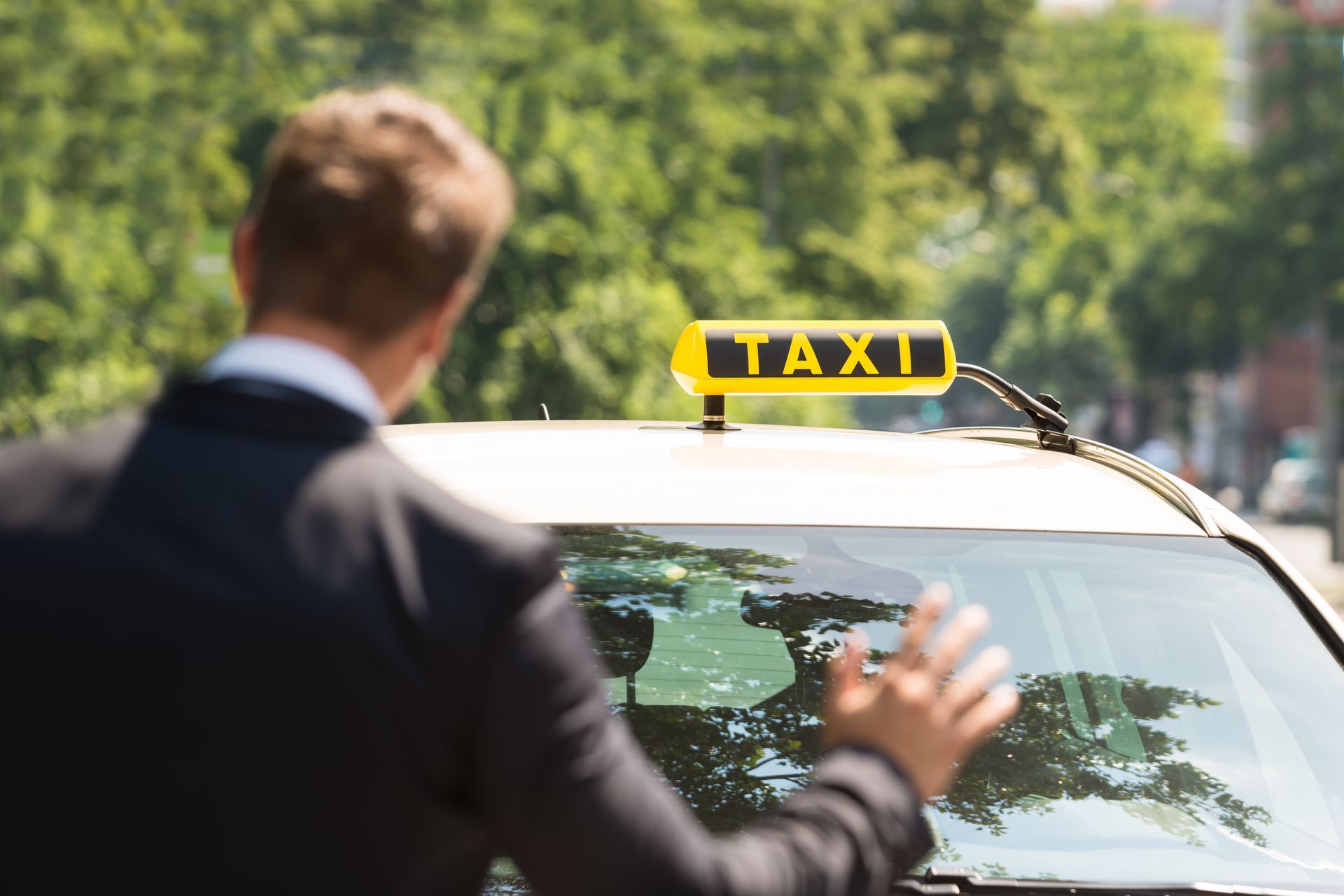 ein Mann in einem Anzug steht vor einem Taxi