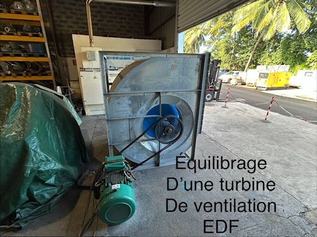 Turbine de ventilation EDF sur palette, avec moteur vert, dans un atelier industriel.