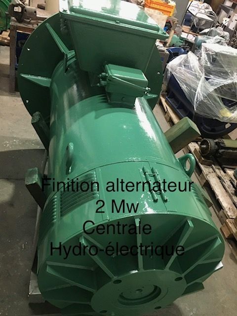 Alternateur vert pour centrale hydroélectrique, présenté dans un atelier.