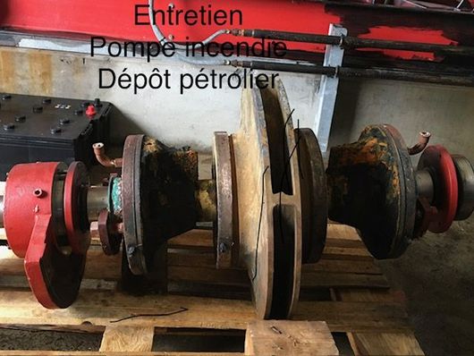 Un noyau de stator de moteur électrique bobiné en cuivre et muni d'ailettes de refroidissement repose sur une surface texturée.